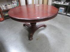 A Victorian mahogany tripod circular dining table (in need of some attention to top fixings).