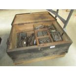 A wooden tool chest containing metal working tools including taps, dies, callipers etc.