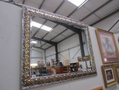A large gilt framed bevel edged mirror.