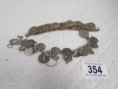 A bracelet of farthings and a charm bracelet including silver threepenny bits.