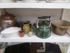 A shelf of vintage kitchen stone ware and enamel ware.