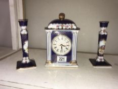 A Past Times ceramic clock and matching candlesticks.