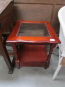 A mahogany coffee table with glass top,