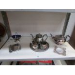 A 3 piece silver plate tea set and other silver plate items (1 shelf).