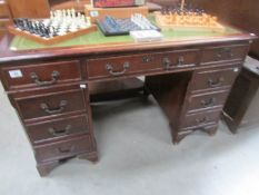 A double pedestal desk with green leather inset top.