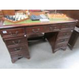 A double pedestal desk with green leather inset top.