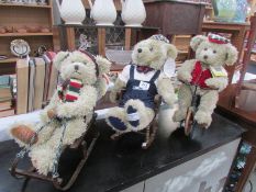3 collectable teddy bears, one on toboggan, one on bicycle and one on rocking chair.