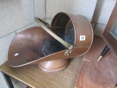 A copper coal scuttle.