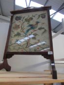 An Edwardian stained wood fire screen with embroidered panel inset.