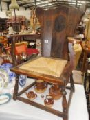 An old oak chair with carved coat of arms in back.