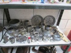 A shelf of assorted metal ware including pewter,.