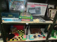 2 shelves of games including chess, scrabble, triominoes, trivial pursuit etc.