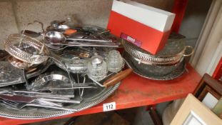 A shelf of silver plate, cutlery etc.