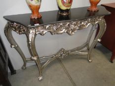 A silver coloured console table.