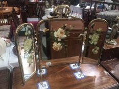 A brass triple fire screen with hand painted mirror insets.