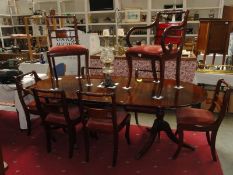 An oval mahogany extending dining table and 8 chairs with brass inlay (some damage to inlay on