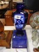 A blue vase on base.