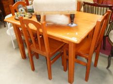 A pine dining table and 4 chairs.