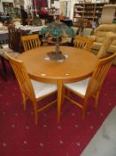 A modern circular dining table and 4 chairs.