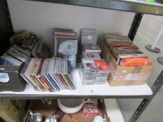 A shelf of CD's, DVD's, tapes and 45 rpm records.