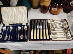 2 cased cutlery set and a quantity of souvenir spoons.