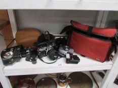 A shelf of camera's, video camera, tripod etc.