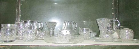 A shelf of miscellaneous glass ware including cut glass, jugs, vases etc.