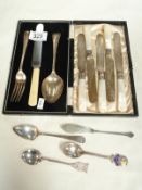A cased knife, fork and spoon together with souvenir spoons.