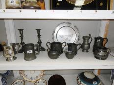 A shelf of metalware including pewter.