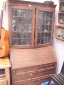 An oak glazed topped bureau cabinet