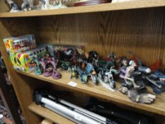 A shelf of fantasy figures including riding motor bikes 2 boxed Maisto VW campervans