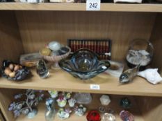 A shelf of glass items, stone eggs,