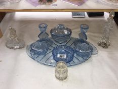 A blue glass bedroom table set and perfume bottles