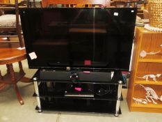 A Luxor 54" flat screen TV with glass TV stand,