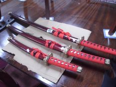 A set of three Samurai swords and parts of a stand