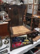 An old oak chair with carved coat of arms in back