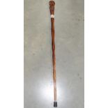 A wooden walking stick with carved kiwi