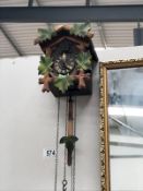 A cuckoo clock with 3 assorted weights