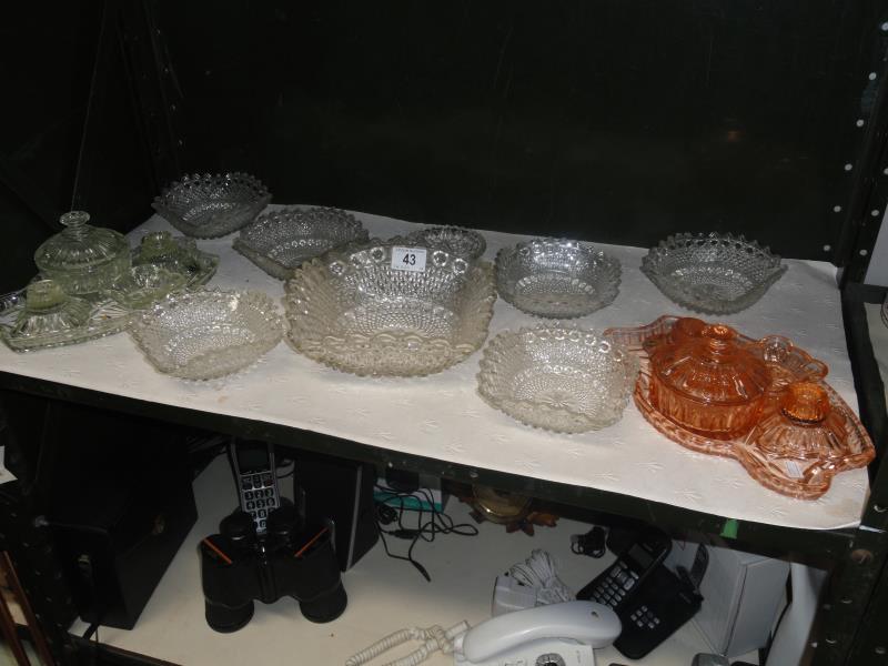 A shelf of assorted glassware including trinket sets etc.