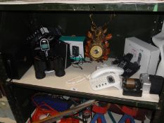 A shelf of micellaneous including telephones & binoculars etc