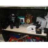 A shelf of micellaneous including telephones & binoculars etc