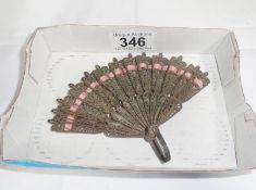 A silver metal filigree fan