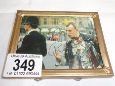 A photo of a punk with policeman signed Johnny Rotten