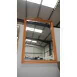 A large wooden framed mirror with carved top piece