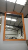 A large wooden framed mirror with carved top piece