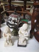 A pair of figures reading books, a Tiffany style table lamp and a Lotto set.