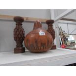 A pair of wooden candlesticks and one other item.