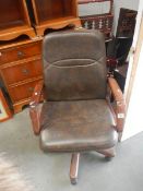 A brown leather and wood revolving office chair.