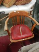 A revolving wooden desk chair with leather seat (leather seat a/f)