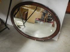 An oval wood framed mirror.